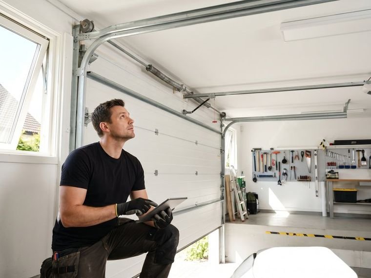 Technician inspecting a garage door and opener rail