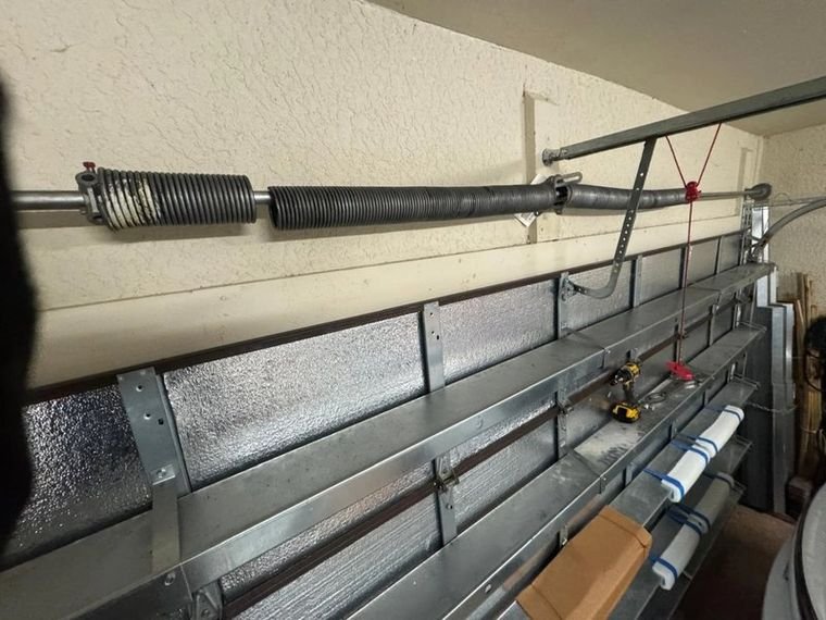 Torsion spring and shaft above a garage door